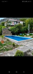 a large swimming pool with a house in the background at Matevosyans Guest House in Goris