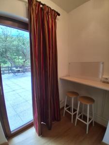 a kitchen with a table and two stools next to a window at Agriturismo Cascina Marchesa in Bussoleno