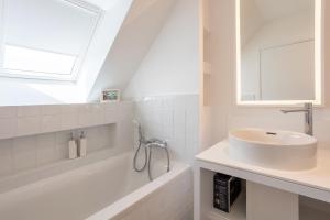 a white bathroom with a sink and a bath tub at Aux flots de la Torche, 3ch in Penmarch +26 photos