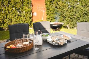a black table with food and wine glasses on it at Design-FeWo Fleesensee, Wallbox, Sauna, Terrasse in Unter Göhren