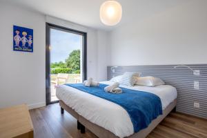 a bedroom with a large bed with a blue blanket at Aux flots de la Torche, 3ch in Penmarch