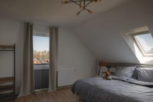 a bedroom with a bed with a teddy bear sitting on it at Design-FeWo Fleesensee, Wallbox, Sauna, Terrasse in Unter Göhren