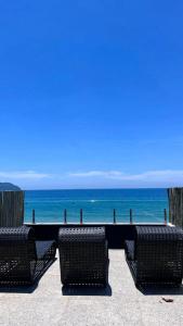 two wicker chairs sitting in front of the ocean at Casatua Pousada in Juquei