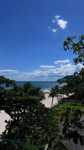 a beach with trees and the ocean in the background at Casatua Pousada in Juquei +99 photos