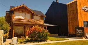 a large wooden house with a black facade at APARTS LA FARFALLA in El Chalten +6 photos