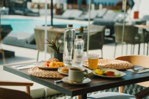 a table with a plate of food and a bottle of water at 001 HIGOS BEACH BOUTIQUE Singular Hotel Residence in Costa Calma