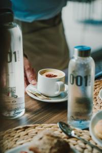 a cup of coffee on a table with a bottle of water at 001 HIGOS BEACH BOUTIQUE Singular Hotel Residence in Costa Calma