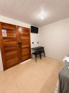 a room with a wooden door and a bench in it at Pousada Serena Jacumã in Jacumã