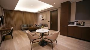 a living room with a table and chairs and a kitchen at سنود النرجس Snood Al Narjis in Riyadh