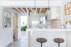 a kitchen with white cabinets and a table at Luxury White Summer Benalmadena in Benalmádena