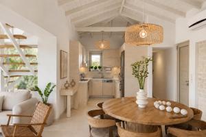 a kitchen and living room with a wooden table and chairs at Villa Pelagos in Koutsounari