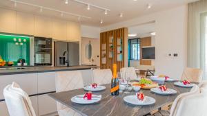 a dining room with a table and a kitchen at Villa Decima near Split - Heated Pool, Tennis Court & Billiards in Dicmo