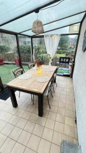 a table and chairs on a patio with a ceiling at Les dunes le Lima in Quend-Plage