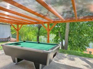 a pool table on a patio with a roof at Pájer Plázs & Resort in Gyomaendrőd