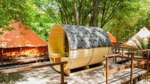 a wooden hobbit house with a roof on a patio at River Tribe Glamping in Laino Borgo