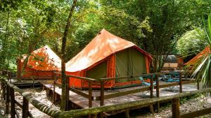 an orange and green tent on a wooden deck at River Tribe Glamping in Laino Borgo
