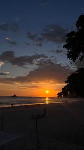 a sunset on a beach with the sun setting at Casatua Pousada in Juquei