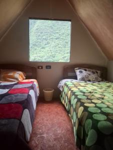 a bedroom with two beds and a window at Refugio Salkantay collpapampa in Colcapampa