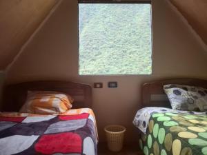 a bedroom with two beds and a window at Refugio Salkantay collpapampa in Colcapampa +9 photos