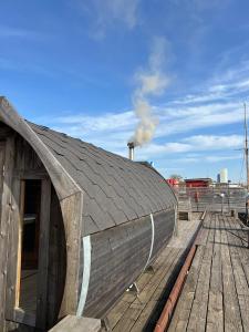 a wooden building with a black roof on a dock at La Mare Resort in Gothenburg
