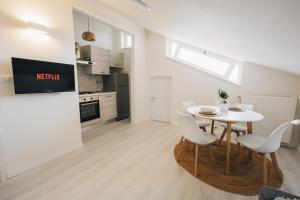 a kitchen and dining room with a white table and chairs at Casa Anastasia Beach Loft in Montesilvano