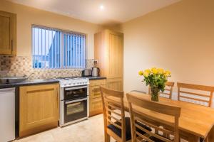 a kitchen with a wooden table and a dining room at Elagh Cottages in Derry Londonderry
