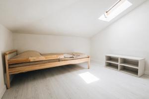 a bedroom with a wooden bed in a white room at Casa Anastasia Beach Loft in Montesilvano