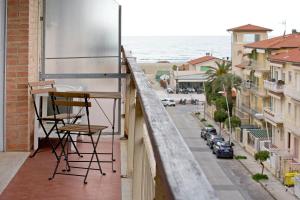 a balcony with a chair and a view of the ocean at Casa Gorgone, SeaFront Flat! in Viareggio