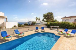 a swimming pool with chairs and a picnic table and the ocean at Villa Claudia by Villa Plus in S'Algar