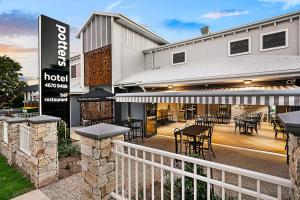a hotel with tables and chairs in front of a building at Potters Toowoomba Hotel in Toowoomba