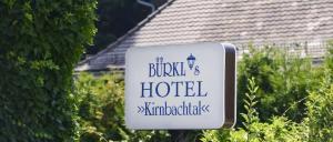 a sign for a hotel in front of a hedge at Hotel Bürkls Kirnbachtal in Niefern-Öschelbronn