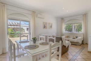 a kitchen and living room with a table and chairs at Chalet Fuente2 piscina común famila in Conil de la Frontera