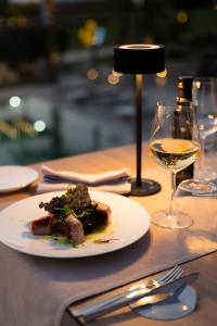 a plate of food on a table with a glass of wine at Terreforti Boutique Spa & Glamping in Agrigento