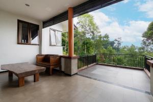 a room with a balcony with a table and a bench at Barusen Hills By BHATARA in Gambung