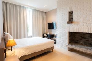 a bedroom with a bed and a fireplace at Hotel Lodewijk Van Male in Bruges