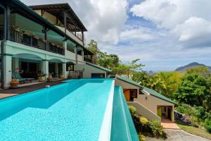 an exterior view of a house with a swimming pool at Studio Lili in Le Diamant