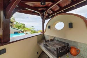 an outdoor grill on the balcony of a house at Studio Lili in Le Diamant