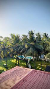 a group of palm trees in a park with a red roof at Niwas Villa in Vihur +12 photos