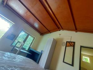 a bedroom with a bed and a wooden ceiling at Almora Nainital-Kausani Highway Kosi Bazar in Almora