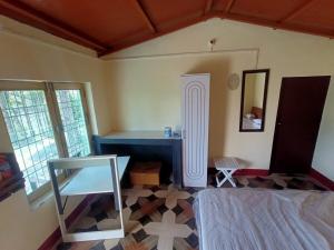 a room with a bed and a table and a mirror at Almora Nainital-Kausani Highway Kosi Bazar in Almora
