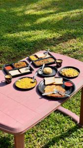 a picnic table with many plates of food on it at Niwas Villa in Vihur