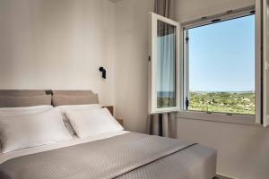 ein Schlafzimmer mit einem Bett und einem großen Fenster in der Unterkunft Ether Villa View in Lithakia