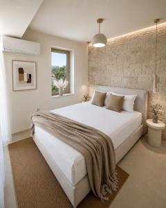 a bedroom with a large white bed and a window at Villa Pelagos in Koutsounari +36 photos