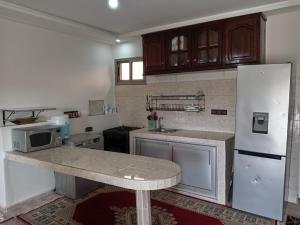 a kitchen with a counter and a white refrigerator at Meditation house in El Jadida