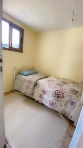 a bedroom with a bed with a floral bedspread and a window at Meditation house in El Jadida +24 photos