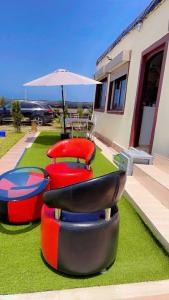 a group of chairs and an umbrella on a lawn at Meditation house in El Jadida