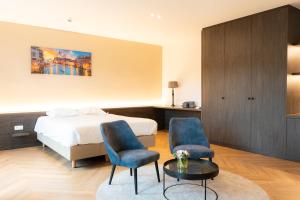 a hotel room with a bed and two chairs and a table at Hotel Lodewijk Van Male in Bruges