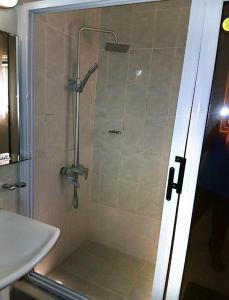 a shower with a glass door next to a sink at Studio Apt-Osu in Christiansborg
