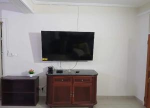 a flat screen tv hanging on a white wall at Studio Apt-Osu in Christiansborg