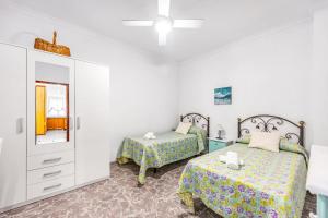 a bedroom with two beds and a mirror at En la Gloria in Barbate